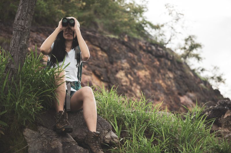 female-tourist-looking-through-binoculars